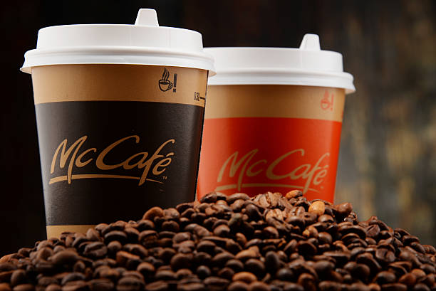 Composition with McCafe coffee cup and beans Poznan, Poland - March 18, 2016: McCafé is a coffee-house-style food and drink chain, owned by McDonald's. mcdonalds drinks stock pictures, royalty-free photos & images