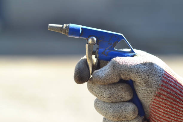 Compressed air gun in the hand of a worker. stock photo