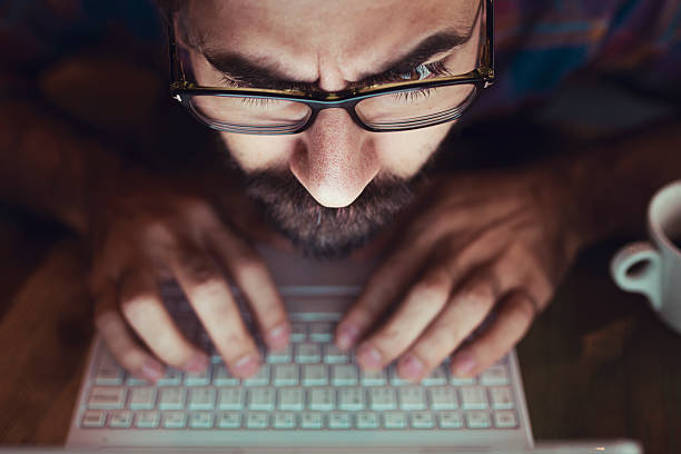 Computer hacker stealing information with laptop stock photo