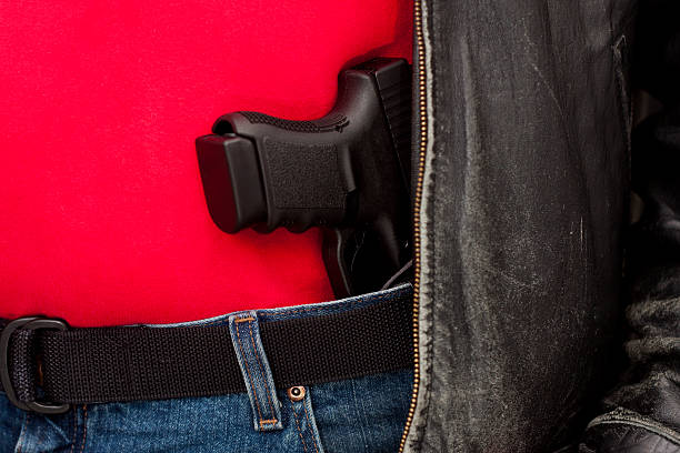 Concealed Firearm Under Jacket "A modern, polymer (Glock), .45 caliber semiautomatic pistol in an IWB holster under a leather jacket.All images in this series..." carrying stock pictures, royalty-free photos & images