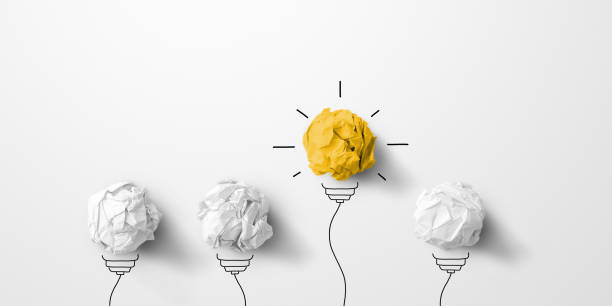 Concept creative idea and innovation. Paper scrap ball yellow colour outstanding different group with light bulb symbol stock photo