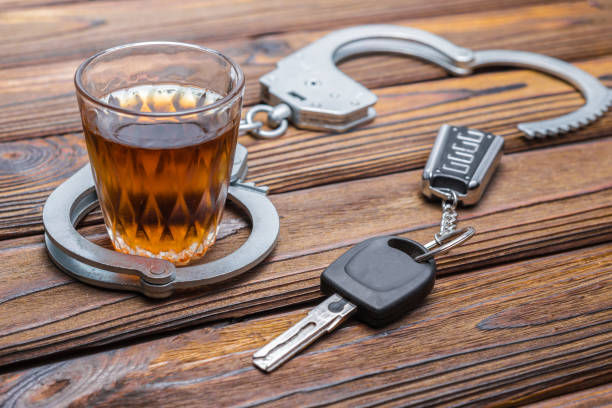 Concept drunkenness driving. Handcuffs, a glass of alcohol, car keys. stock photo