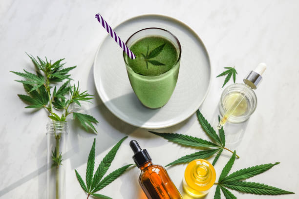 Concept edibles CBD and drinks with cannabis . Glasses with fresh beverage, smoothies, with hemp. Flat lay stock photo
