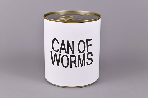 Concept for dfifficult and bad situations and unpleasant experiences showing a tin can with white label and words 'Can of worms' on gray background