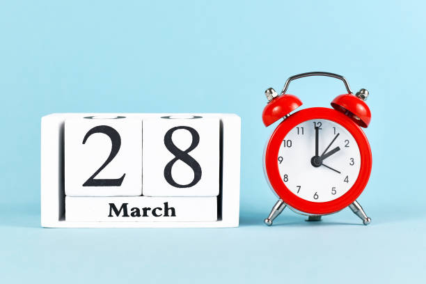 Concept for time change for daylight saving summer time in Europe on March 28th with red alarm clock and calendar Concept for time change for daylight saving summer time in Europe on March 28th with red alarm clock and calendar on blue background daylight savings time 2021 stock pictures, royalty-free photos & images