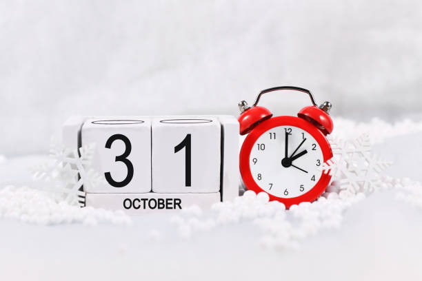 Concept for time change for daylight saving winter time in Europe on October 31st Concept for time change for daylight saving winter time in Europe on October 31st with red alarm clock and calendar in snow daylight savings time 2021 stock pictures, royalty-free photos & images