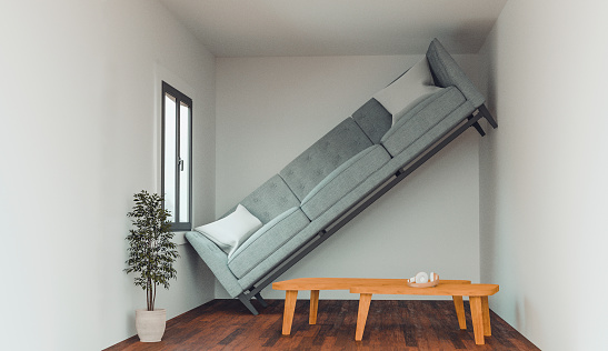 Concept of a living in a home that is not big enough for your dreams and items. Sofa cannot fit into the living room and stand up against a wall.