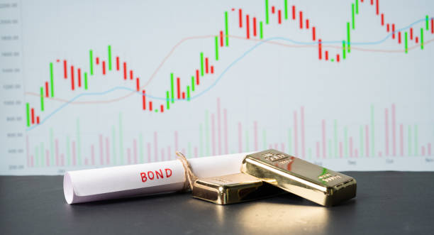 Concept of gold bond showing with Gold bars and Bod paper with Stock Market Graphs or charts in background. Concept of gold bond showing with Gold bars and Bod paper with Stock Market Graphs or charts in background stock market in india  stock pictures, royalty-free photos & images