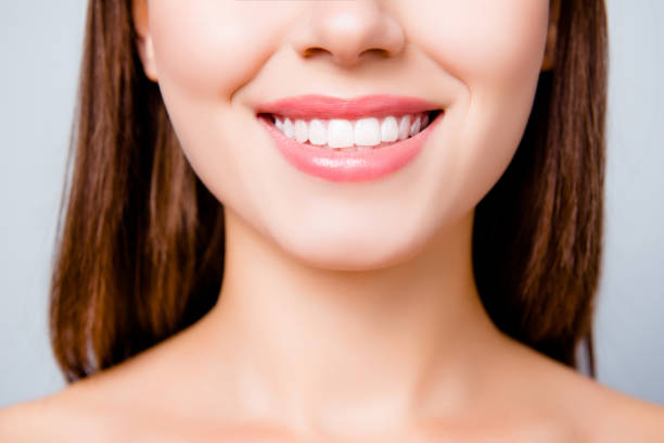 Concept of healthy wide beautiful smile. Cropped close up photo of healthy without caries shiny toothy woman's smile, isolated on grey background Concept of healthy wide beautiful smile. Cropped close up photo of healthy without caries shiny toothy woman's smile, isolated on grey background teeth stock pictures, royalty-free photos & images