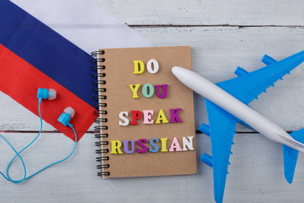 Concept of learning Russian language - colorful letters with text "Do you speak Russian", flag of the Russia, airplane, headphones stock photo