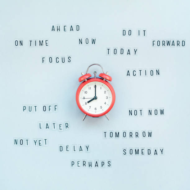 Concept of procrastination and time management Creative top view flat lay of alarm clock with messages about delay or starting doing task copy space blue background minimal style. Concept of procrastination, time management in business and life wasting time stock pictures, royalty-free photos & images