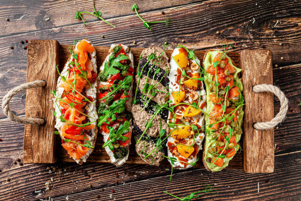 Concept of Spanish cuisine. Tapas Different bruschetta on a fried baguette. Serving dishes in the restaurant. Background image. Copy space. Concept of Spanish cuisine. Tapas Different bruschetta on a fried baguette. Serving dishes in the restaurant. Background image. Copy space. crostini photos stock pictures, royalty-free photos & images
