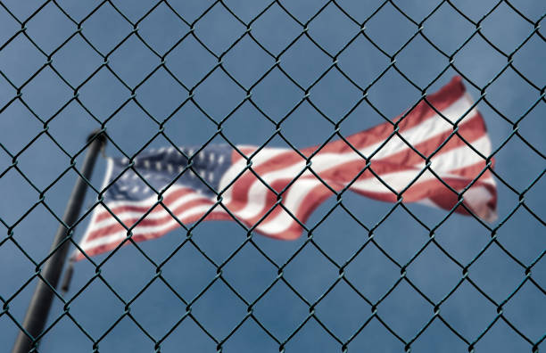 Concept of United States of America closed borders with flag and wire fence. USA immigration and homeland security. American dream concept, not accessible and hard to reach.  immigrant stock pictures, royalty-free photos & images