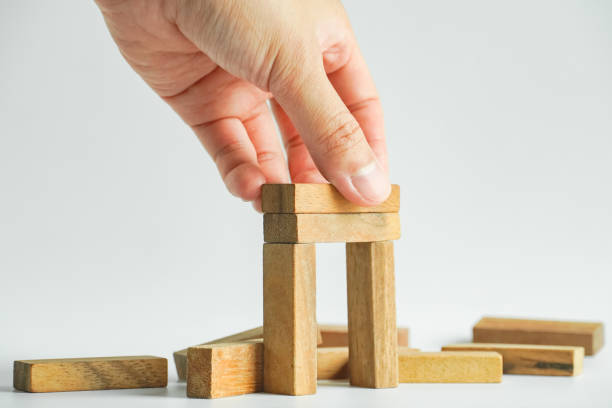 Concept risk for business, wood block stack for architecture model and concept of business risk management for strategy plan. stock photo