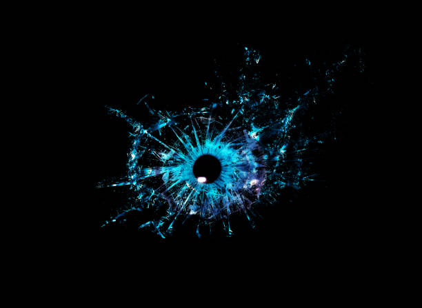 Conceptual creative photo of a blue human eye close-up macro that breaks into small pieces of glass isolated on a black background. stock photo