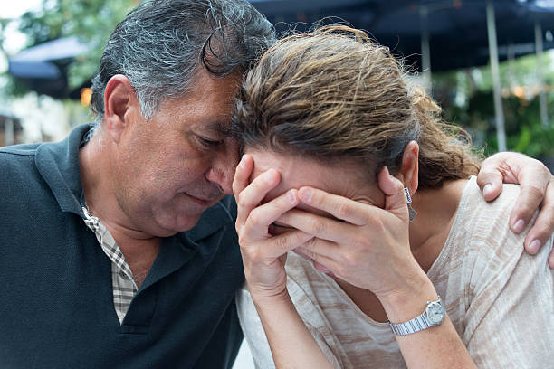 concerned hispanic couple - embrace man woman serious stockfoto's en -beelden