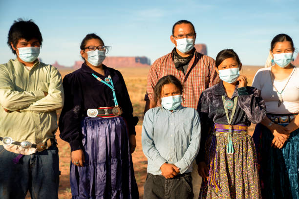 A Concerned Navajo Father And His Children Wearing Masks To Protect Themselves During The Covid19 Shutdown A Navajo family with the Monument Valley behind them stand together wearing masks for protection during the Coronavirus pandemic navajo nation covid stock pictures, royalty-free photos & images