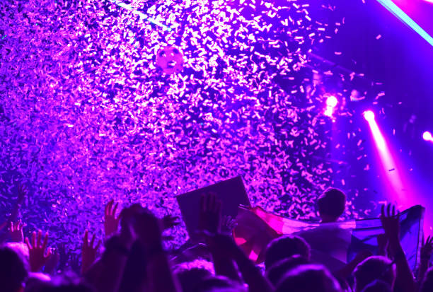 Concert crowd in front of bright stage lights with confetti stock photo