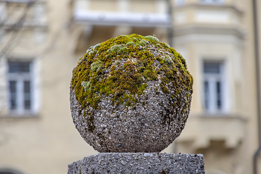 Concrete orb partly covered with moss seen in the center of the German city Munich which is the capital city in Bavaria