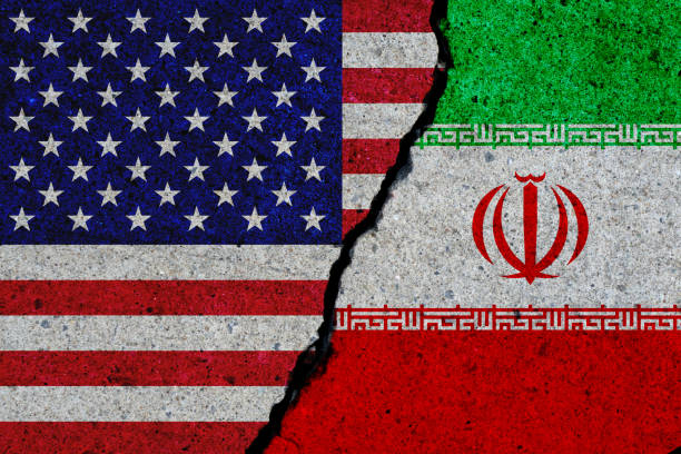 concrete wall with painted united states and iran flags stock photo