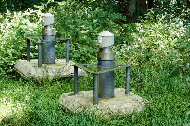 Concreted well heads of groundwater monitoring wells with steel collision protection in a forest stock photo