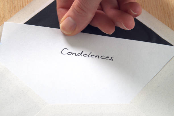 Condolences, hand pulling letter from envelope stock photo