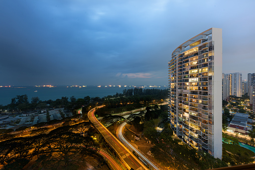 Modern residential condominium building complex overlooking the Singapore sea strait with the ECP highway, at sunset