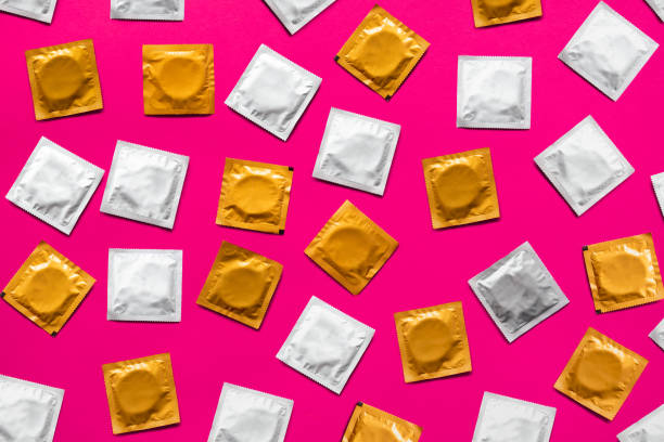 Condoms in pink background, top view. stock photo
