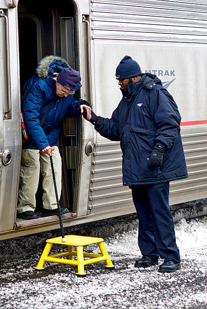 Conductor helps Amtrak passenger stock photo