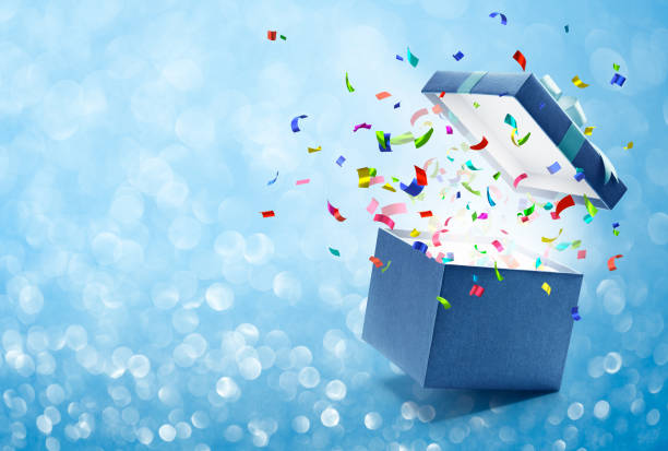 Confetti popping out from gift box Confetti popping out from blue gift box - bokeh background birthday present stock pictures, royalty-free photos & images