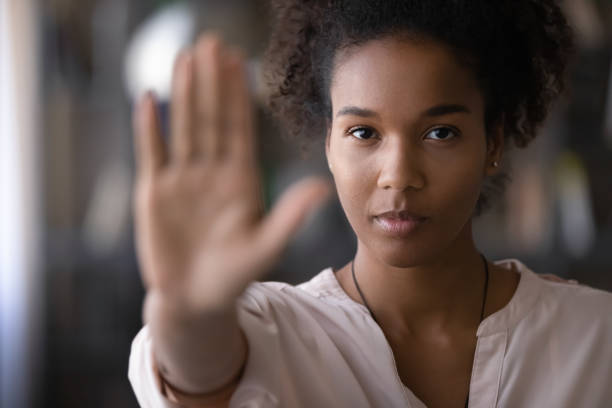 Confident african young woman showing stop signal. stock photo
