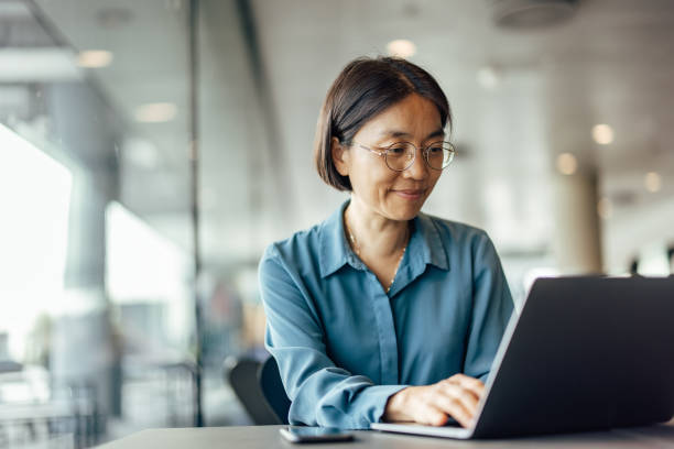 confident asian woman, trying to help her customers - computeren stockfoto's en -beelden