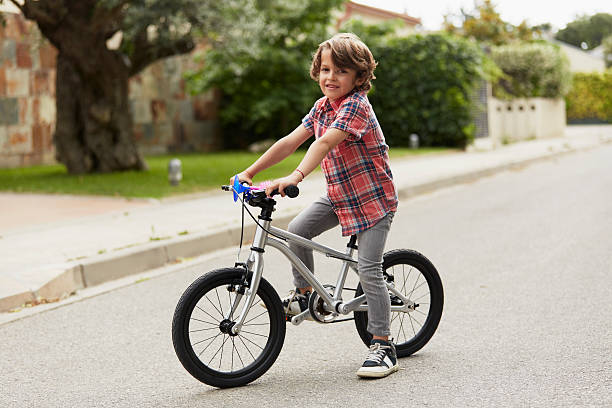 confident boy sitting on bicycle - 6 7 jahre stock-fotos und bilder