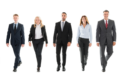Confident Business People Walking Against White Background