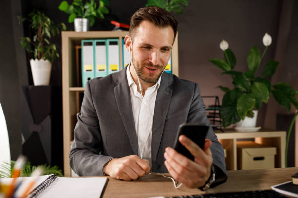 Confident businessman video conferencing with a colleague via smart phone stock photo