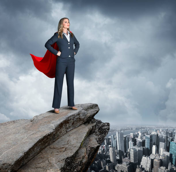 Confident Businesswoman Stands Ready To Take On World A very confident businesswoman stands with her hands on her hips on top of a rocky view point that looks over the New York City skyline. headland stock pictures, royalty-free photos & images