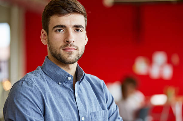 Confident male designer working in red creative office space stock photo