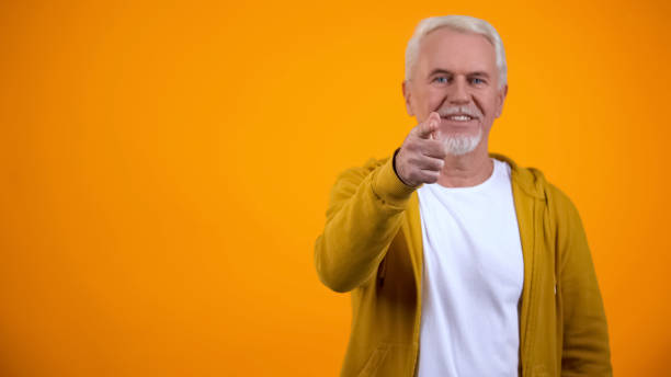 Confident modern senior man pointing finger on camera, welcoming to nursing home Confident modern senior man pointing finger on camera, welcoming to nursing home nurse talking to camera stock pictures, royalty-free photos & images