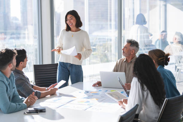 Confident woman giving a presentation with a group of people stock photo