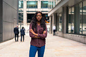 A woman standing on a street in London's financial district.