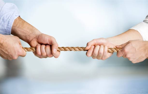 Conflict. Business people pulling rope in opposite directions at office conflict stock pictures, royalty-free photos & images