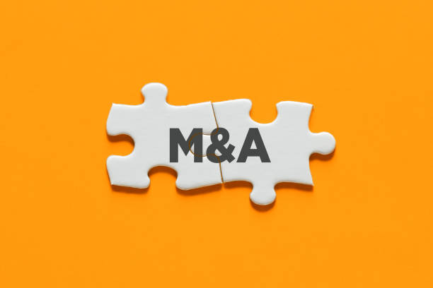 Connected puzzle pieces with the acronym M&A. Merger and acquisition in business stock photo