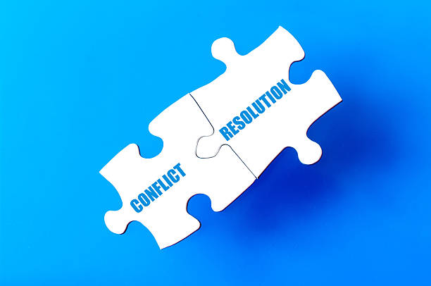 Connected puzzle pieces with words CONFLICT and RESOLUTION Connected puzzle pieces with words CONFLICT and RESOLUTION  isolated over blue background, with copy space available. Business concept image. Conflict resolution stock pictures, royalty-free photos & images
