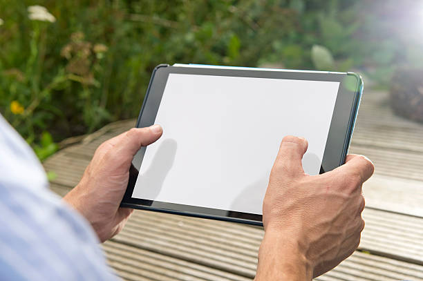 Connectivity: Man using tablet outdoors stock photo