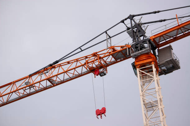 construction crane with long arm pointing down stock photo