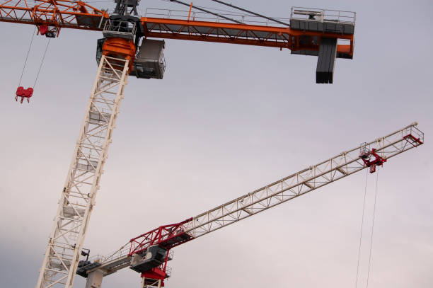 2 construction cranes,, their arm forming an open triangle. stock photo