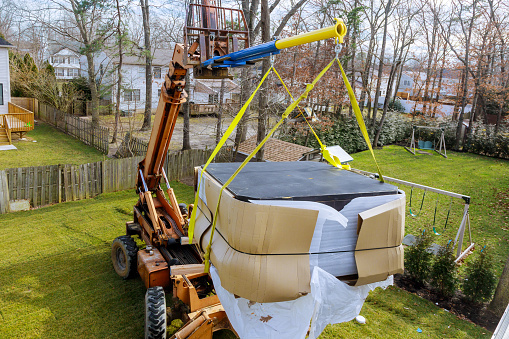 A moving forklift suspending a hot tub ready for moving