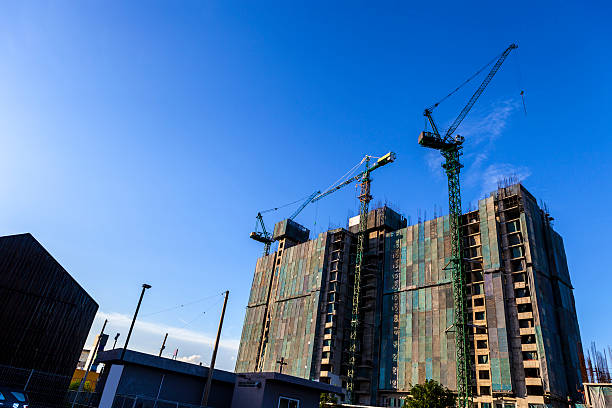 construction of high-rise buding by tower cranes and the canvas - verhuislift stockfoto's en -beelden