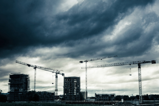 Constructions and cranes under dramatic sky