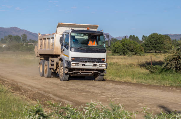 Construction truck moving fast with load of rock and sand on dirt road stock photo